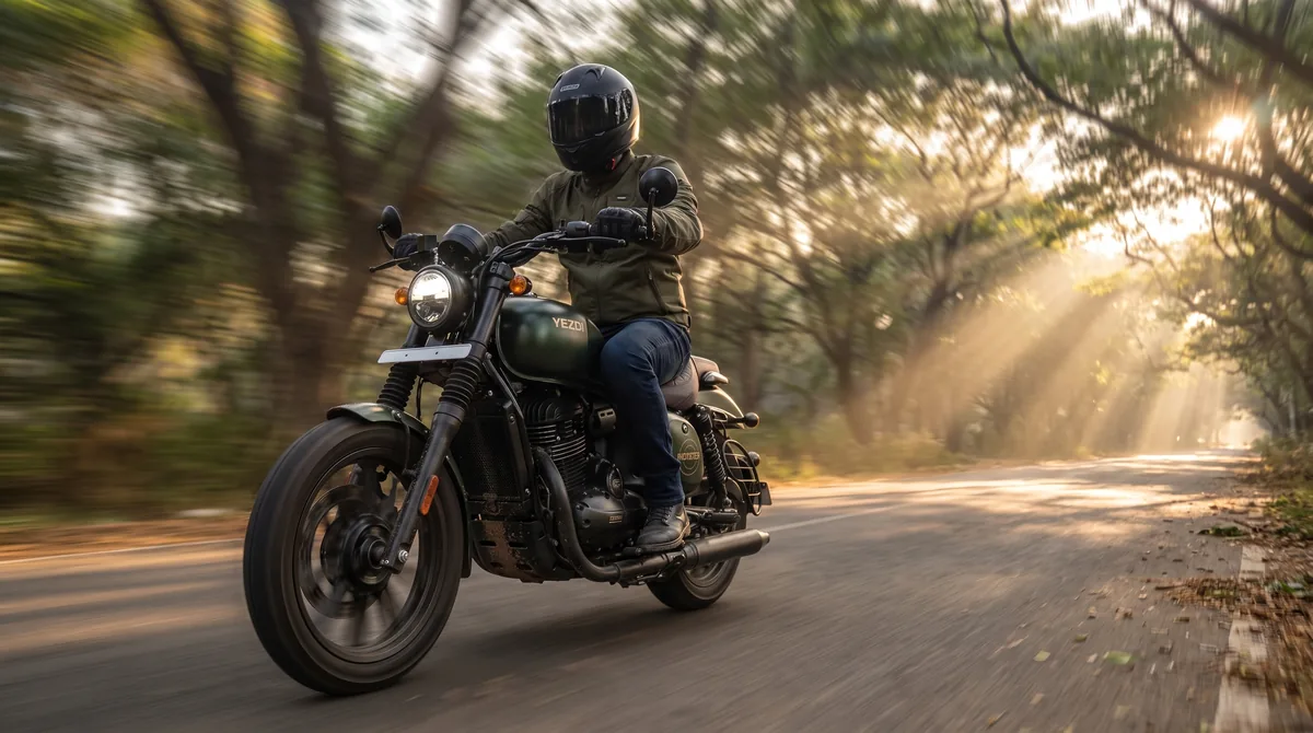 A rider on a Green Mamba Yezdi Roadster under a rain-tree avenue in Bengaluru at sunrise.