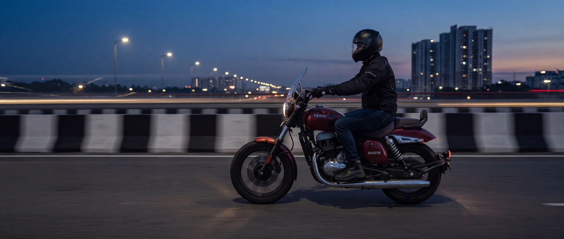 A rider on a Red Wolf Yezdi Roadster on a Bengaluru expressway before sunrise.